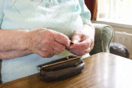 Elderly woman checking her purse for cash