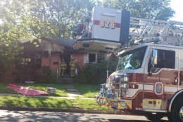 Photo shows a fire truck in front of a burned out home