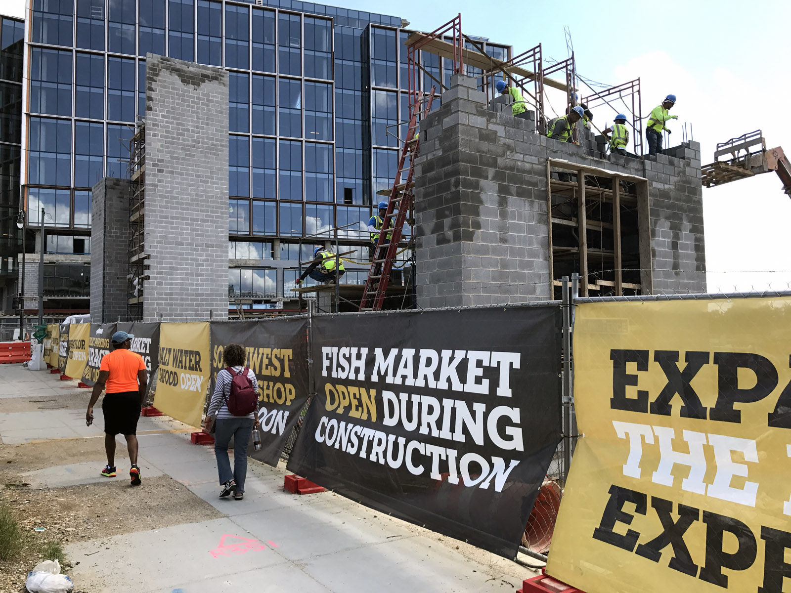 From Maine Avenue, construction on Nicholas Stefanelli's Italian market, restaurant and lounge, can be seen. A new office building sits behind the market. The improvements are part of the mile-long redevelopment of the Southwest Waterfront called The Wharf. (WTOP/Michelle Basch)