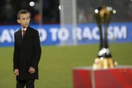 The son of Morocco's King Mohammed VI, Moulay Hassan, stands next to the trophy ahead of the final soccer match between Real Madrid and San Lorenzo at the Club World Cup soccer tournament in Marrakech, Morocco, Saturday, Dec. 20, 2014. (AP Photo/Christophe Ena)