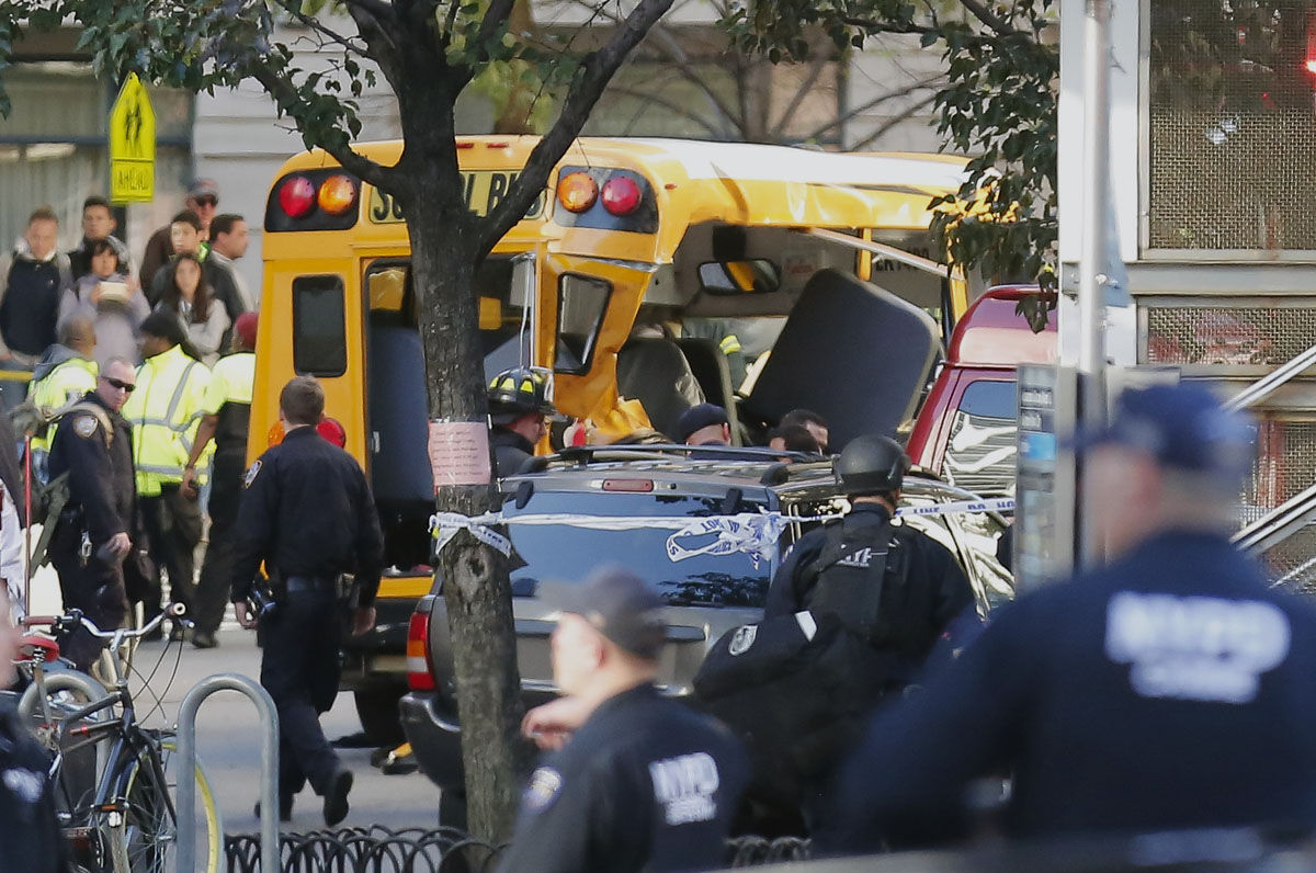 Authorities respond near a damaged school bus Tuesday, Oct. 31, 2017, in New York. A motorist drove onto a busy bicycle path near the World Trade Center memorial and struck several people on Tuesday police and witnesses said. (AP Photo/Bebeto Matthews)