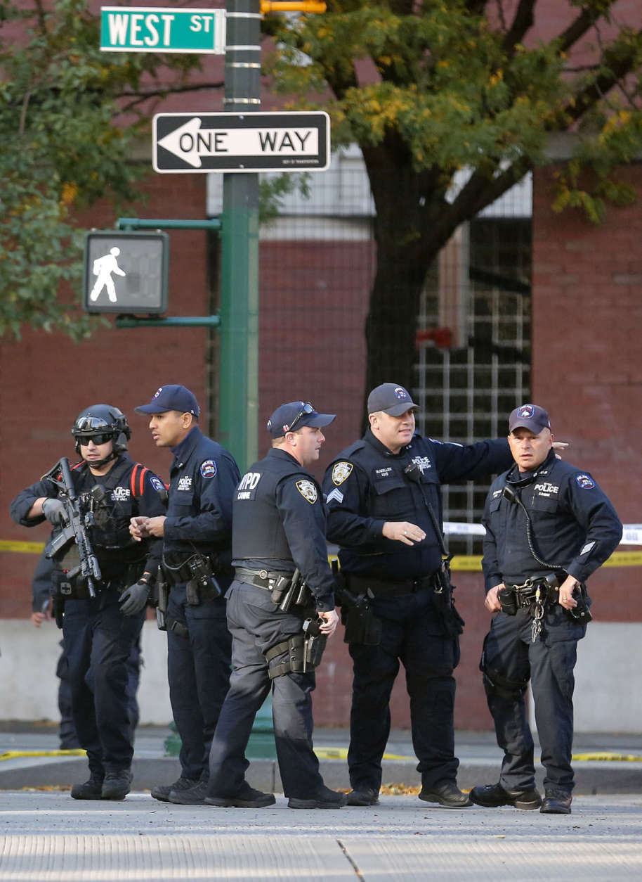 New York Police Department officers gather near the scene Tuesday Oct. 31, 2017, in New York. A motorist drove onto a busy bicycle path near the World Trade Center memorial and struck several people Tuesday, police and witnesses said. (AP Photo/Bebeto Matthews)