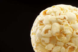 Closeup view of popcorn ball isolated on black with copy space. (Thinkstock)