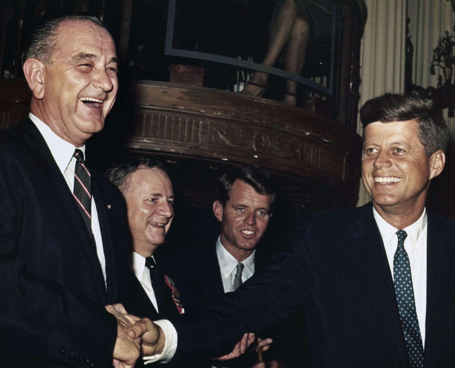 John F. Kennedy, at right,  stands with Lyndon Baines Johnson before the Texas delegation caucus in Los Angeles July 12, 1960 prior to the Democratic Convention.   Both Senators are Democratic contenders for the Presidential nomination.  Behind Senator Kennedy is his brother Robert F. Kennedy, his campaign manager.  Man behind Senator Johnson at left rear is unidentified.  (AP Photo)