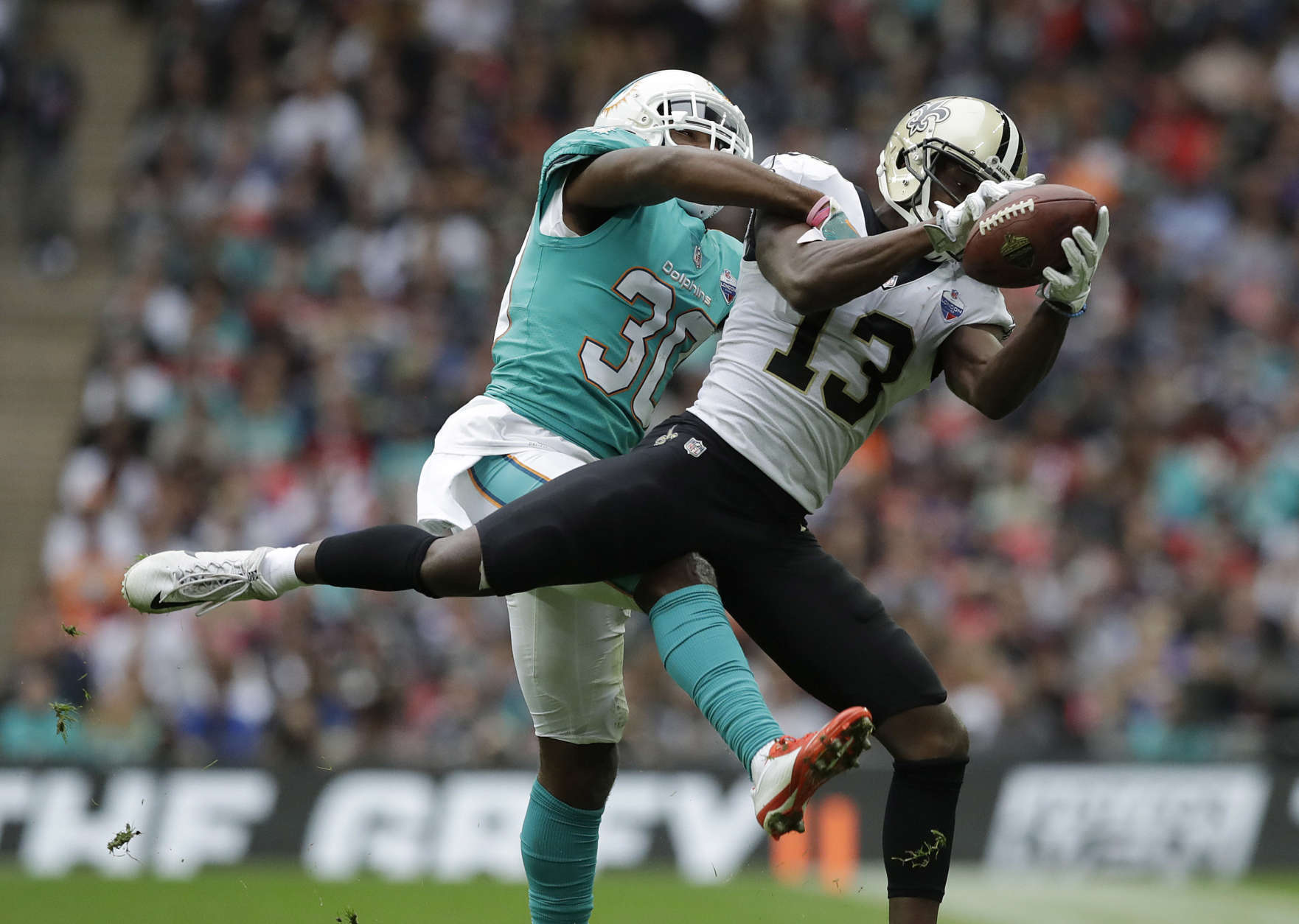 New Orleans Saints wide receiver Michael Thomas (13) catches a pass in front of Miami Dolphins cornerback Cordrea Tankersley (30) during the first half of an NFL football game at Wembley Stadium in London, Sunday Oct. 1, 2017. (AP Photo/Matt Dunham)