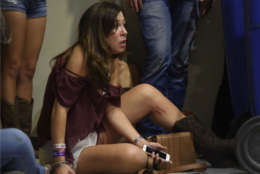 A woman hides inside the Sands Corporation plane hangar after a mass shooting in which dozens were killed at the Route 91 Harvest Festival on Sunday, Oct. 1, 2017, in Las Vegas. (Al Powers/Invision/AP)