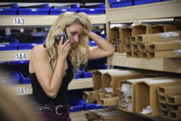 A concertgoer makes a phone call early Monday, Oct. 2, 2017, while hiding inside the Sands Corporation plane hangar after a gunman opened fire at the Route 91 Harvest country festival in Las Vegas. (Al Powers/Invision/AP)