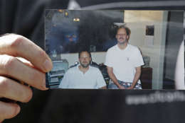 Eric Paddock holds a photo of him, at left, and his brother, Stephen Paddock, at right, outside his home, Monday, Oct. 2, 2017, in Orlando, Fla. Stephen Paddock opened fire on the Route 91 Harvest Festival on Sunday killing dozens and wounding hundreds. (AP Photo/John Raoux)