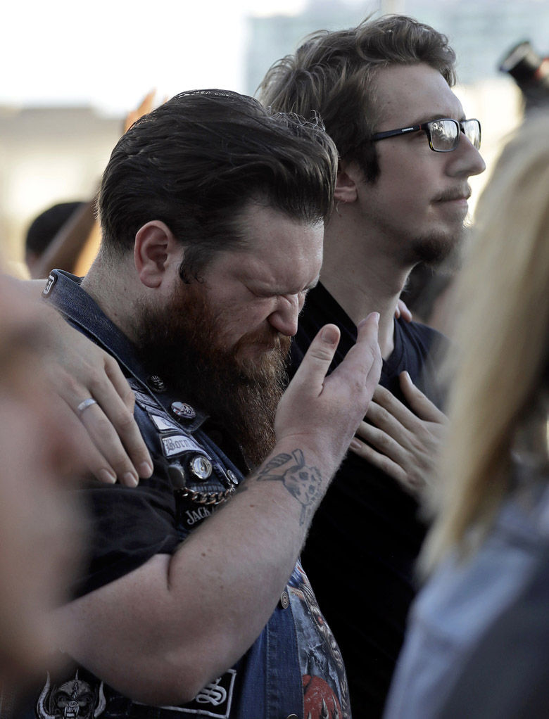 Sean Bolger is comforted by a friend during a vigil at City Hall in Las Vegas, Monday, Oct. 2, 2017. The vigil was held in honor of the over 50 people killed and hundreds injured in a mass shooting at an outdoor music concert late Sunday. (AP Photo/Gregory Bull)