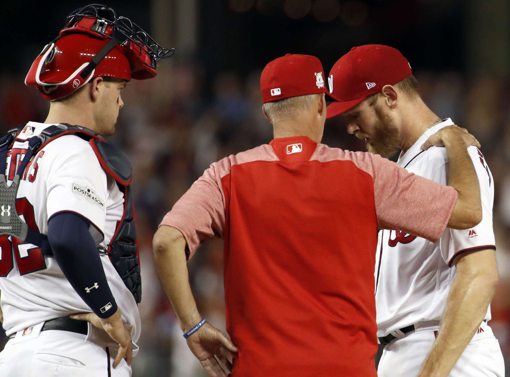 Washington Nationals catcher Matt Wieters,l left, and pitching coach Mike Maddux, center, talk with Washington Nationals starting pitcher Stephen Strasburg on the mound during Game 1 of baseball's National League Division Series against the Chicago Cubs, at Nationals Park, Friday, Oct. 6, 2017, in Washington. (AP Photo/Alex Brandon)