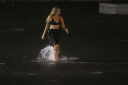 A woman wades through a flooded Water St. in downtown Mobile, Ala., during Hurricane Nate, Sunday, Oct. 8, 2017, in Mobile, Ala. (AP Photo/Brynn Anderson)