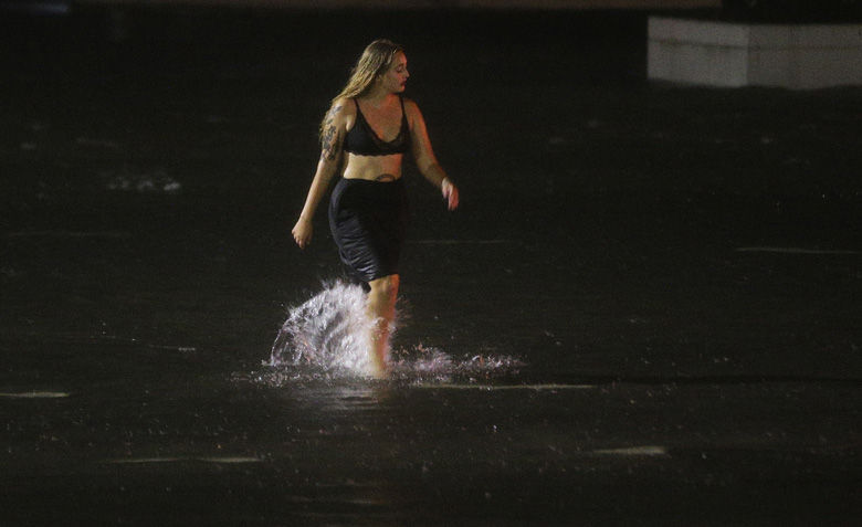 A woman wades through a flooded Water St. in downtown Mobile, Ala., during Hurricane Nate, Sunday, Oct. 8, 2017, in Mobile, Ala. (AP Photo/Brynn Anderson)
