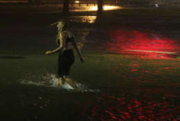 A woman wades through a flooded Water St. in downtown Mobile, Ala., during Hurricane Nate, Sunday, Oct. 8, 2017, in Mobile, Ala.  Hurricane Nate came ashore along Mississippi's coast outside Biloxi early Sunday, the first hurricane to make landfall in the state since Hurricane Katrina in 2005.(AP Photo/Brynn Anderson)