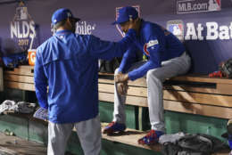 Chicago Cubs bench coach Dave Martinez, left, consoles Chicago Cubs relief pitcher Carl Edwards Jr., in the dugout during the seventh inning in Game 5 of baseball's National League Division Series against the Washington Nationals at Nationals Park, Thursday, Oct. 12, 2017, in Washington. (AP Photo/Pablo Martinez Monsivais)