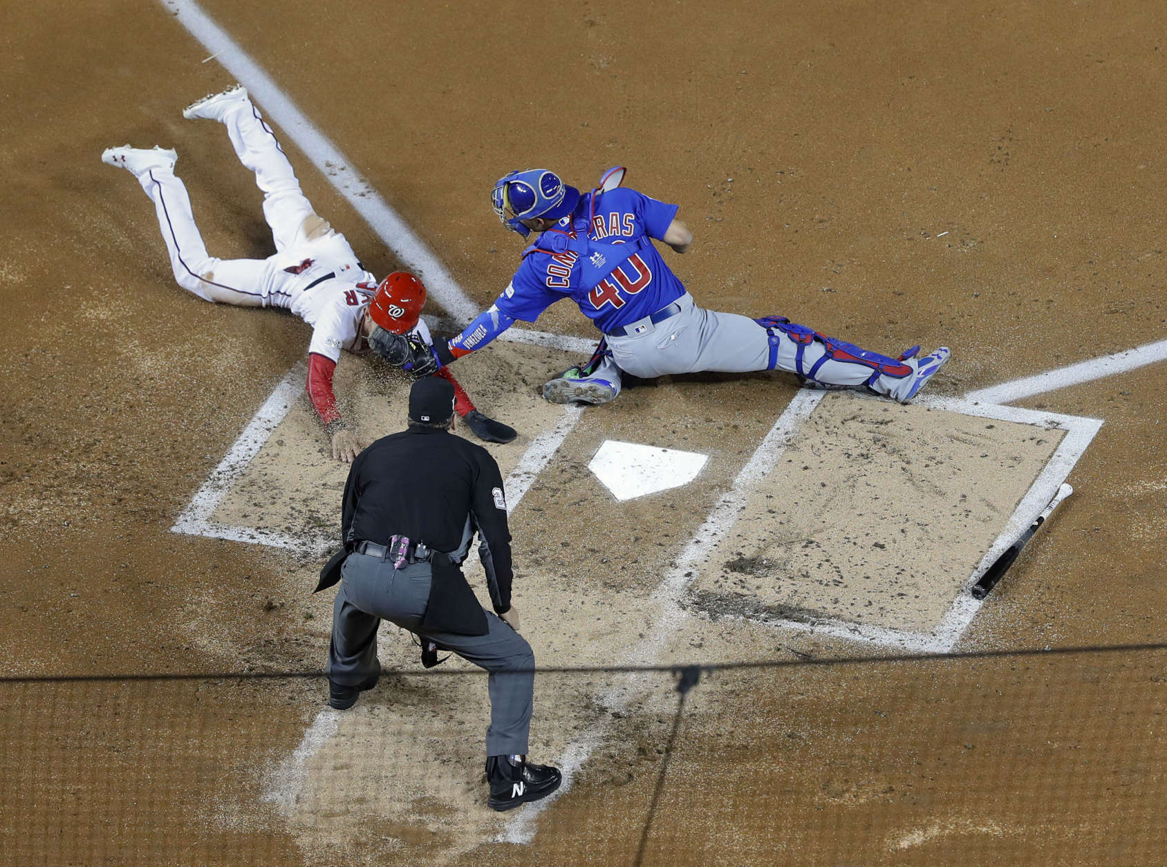 Chicago Cubs catcher Willson Contreras (40) tags out Washington Nationals Trea Turner (7) at home on a infield grounder by Bryce Harper during the first inning of Game 5 of baseball's National League Division Series, at Nationals Park, Thursday, Oct. 12, 2017, in Washington. Behind the plate is umpire Jerry Lane.  The Cubs won 9-8. (AP Photo/Pablo Martinez Monsivais)