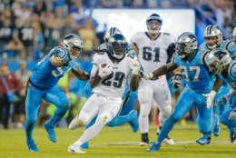 Philadelphia Eagles' LeGarrette Blount (29) runs away from Carolina Panthers' Shaq Green-Thompson (54) and by Mario Addison (97) during the first half of an NFL football game in Charlotte, N.C., Thursday, Oct. 12, 2017. The Eagles won 28-23. (AP Photo/Bob Leverone)