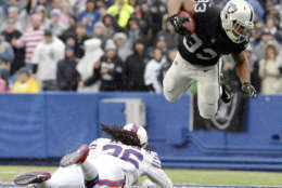 As rain falls, Oakland Raiders running back DeAndre Washington, right, goes airborne after being hit by Buffalo Bills defensive back Trae Elston during the first half of an NFL football game, Sunday, Oct. 29, 2017, in Orchard Park, N.J. (AP Photo/Adrian Kraus)