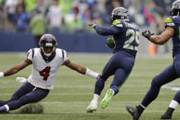 Seattle Seahawks free safety Earl Thomas, second from left, avoids a tackle-attempt by Houston Texans quarterback Deshaun Watson (4) after intercepting a pass from Watson in the first half of an NFL football game, Sunday, Oct. 29, 2017, in Seattle. Thomas returned the interception 78 yards for a touchdown. (AP Photo/Stephen Brashear)