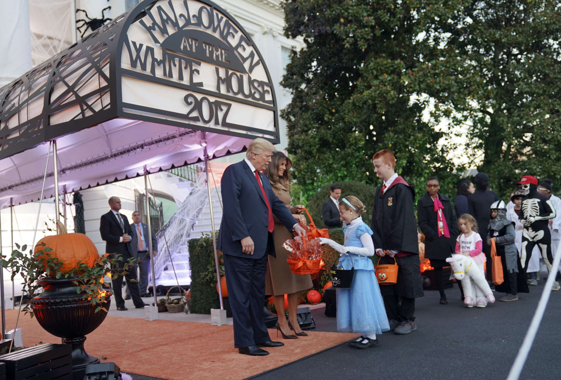President Donald Trump and first lady Melania Trump hand out treats as they welcome children from the Washington area and children of military families to trick-or-treat for Halloween at the South Lawn of the White House in Washington, Monday, Oct. 30, 2017. (AP Photo/Pablo Martinez Monsivais)