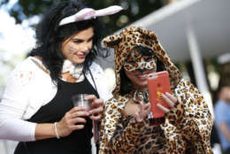 Annabel Sanchez, left, and Grety Artiles stop to take a selfie as they walk along the Lincoln Road pedestrian mall for Halloween, Tuesday, Oct. 31, 2017, in the South Beach neighborhood of Miami Beach, Fla. (AP Photo/Wilfredo Lee)