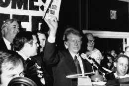 Democratic presidential nominee Jimmy Carter, center, waves a copy of the New York Daily News carrying a headline &quot;Ford to City: Drop Dead&quot; during a reception at a Queens, N.Y., restaurant, Oct. 15, 1976. Standing behind the former Georgia governor are, from left: state Democratic nominee for U.S Senate, Daniel Patrick Moynihan, Queens borough President Donald Manes and Gov. Hugh Carey, partially hidden. (AP Photo)