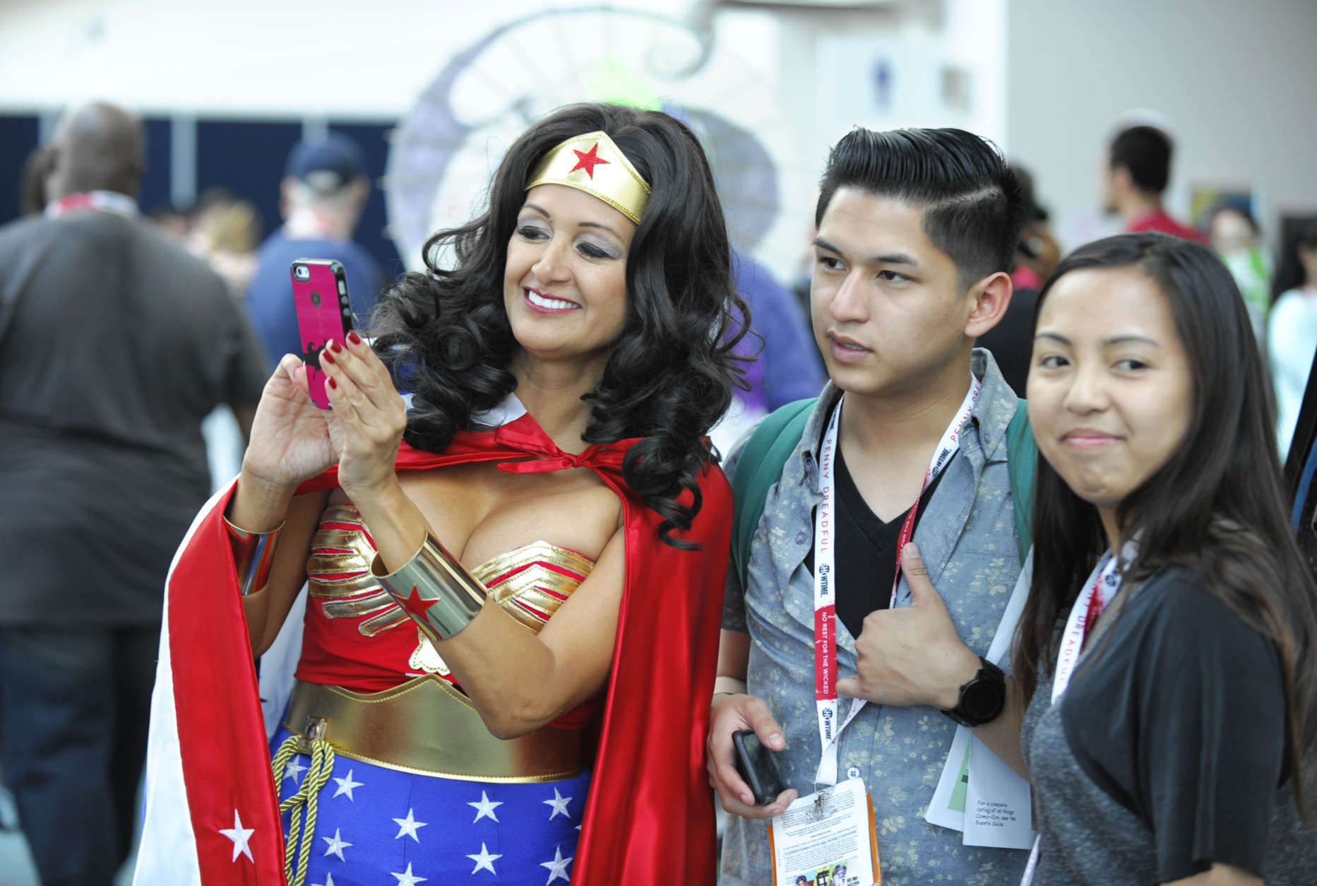 Michelle Camarillo, dressed as Wonder Woman, looks at a selfie on the second day of the 2015 Comic-Con International held at the San Diego Convention Center Friday, July 10, 2015, in San Diego.  The pop-culture event runs July 9-12.  (Photo by Denis Poroy/Invision/AP)