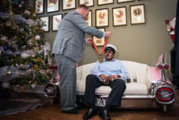 Legendary musician Fats Domino is named  "Honorary Grand Marshall" of the Krewe of Orpheus, the star-studded Carnival club that traditionally parades the night before Mardi Gras, Friday, Dec. 20, 2013 in New Orleans. Michael Murphy II of the Krewe of Orpheus presents a medal to Fats Domino.(AP Photo/Doug Parker).