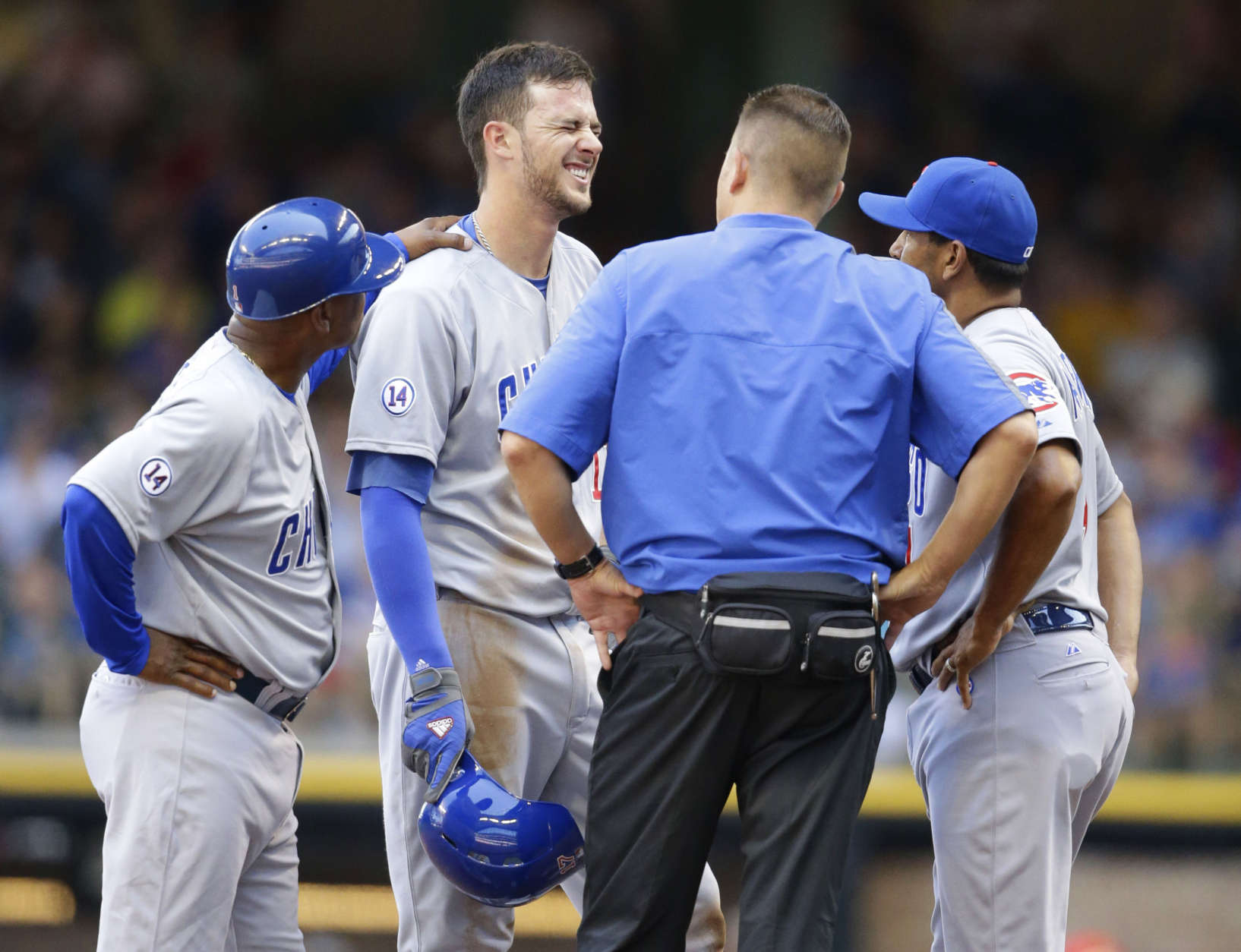 Chicago Cubs' Kris Bryant reacts at second base with third base coach Gary Jones, left a trainer and Dave Martinez, right, after Bryant was injured while sliding into second base during the fifth inning of a baseball game against the Milwaukee Brewers, Sunday, Aug. 2, 2015, in Milwaukee. Bryant was hurt on the play and left the game. (AP Photo/Jeffrey Phelps)