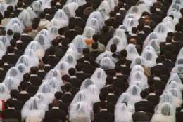 Some of the 28,000 couples participate in a marriage affirmation ceremony officiated by the Rev. and Mrs. Sun Myung Moon, founders of the Unification Church, at RFK Stadium, Saturday, Nov. 29, 1997, in Washington. D.C. (AP Photo/Ken Cedeno)