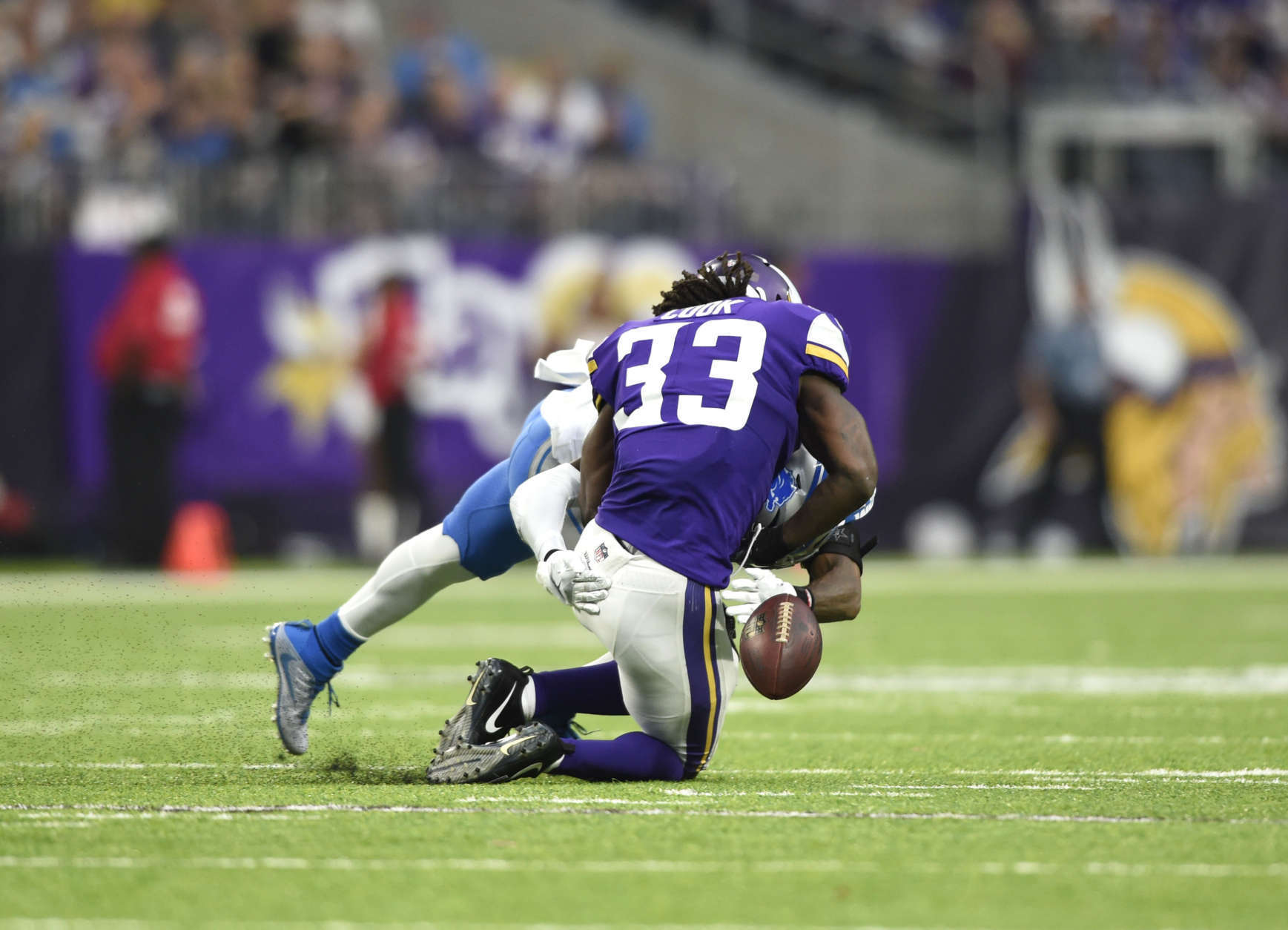 MINNEAPOLIS, MN - OCTOBER 1: Dalvin Cook #33 of the Minnesota Vikings fumbles the ball while being tackled by defender Tavon Wilson #32 of the Detroit Lions in the third quarter of the game on October 1, 2017 at U.S. Bank Stadium in Minneapolis, Minnesota. Cook was injured on the play and left the game for the locker room. (Photo by Hannah Foslien/Getty Images)