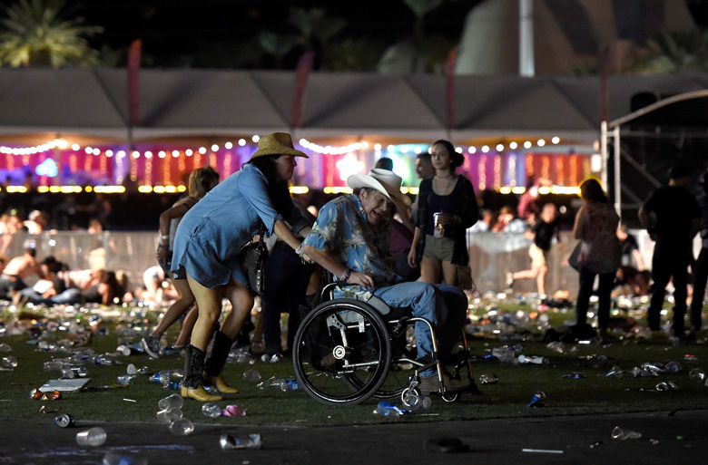 LAS VEGAS, NV - OCTOBER 01:   A man in a wheelchair is taken away from the Route 91 Harvest country music festival after apparent gun fire was heard on October 1, 2017 in Las Vegas, Nevada.  There are reports of an active shooter around the Mandalay Bay Resort and Casino.  (Photo by David Becker/Getty Images)