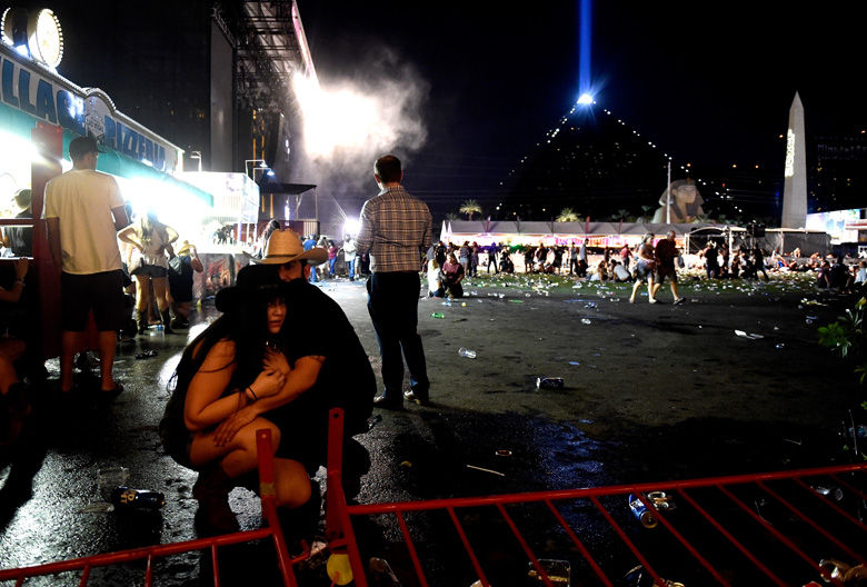 LAS VEGAS, NV - OCTOBER 01:  People take cover at the Route 91 Harvest country music festival after apparent gun fire was heard on October 1, 2017 in Las Vegas, Nevada.  There are reports of an active shooter around the Mandalay Bay Resort and Casino.  (Photo by David Becker/Getty Images)