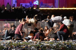 LAS VEGAS, NV - OCTOBER 01:  People scramble for shelter at the Route 91 Harvest country music festival after apparent gun fire was heard on October 1, 2017 in Las Vegas, Nevada. A gunman has opened fire on a music festival in Las Vegas, leaving at least 20 people dead and more than 100 injured. Police have confirmed that one suspect has been shot. The investigation is ongoing. (Photo by David Becker/Getty Images)