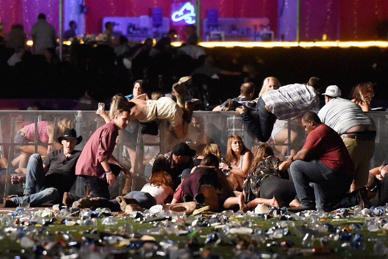 LAS VEGAS, NV - OCTOBER 01:  People scramble for shelter at the Route 91 Harvest country music festival after apparent gun fire was heard on October 1, 2017 in Las Vegas, Nevada. A gunman has opened fire on a music festival in Las Vegas, leaving at least 20 people dead and more than 100 injured. Police have confirmed that one suspect has been shot. The investigation is ongoing. (Photo by David Becker/Getty Images)