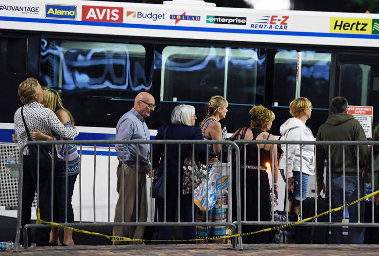 LAS VEGAS, NV - OCTOBER 02:  People wait to get on a McCarran International Airport rental car bus outside the Thomas &amp; Mack Center after a mass shooting at a country music festival on October 2, 2017 in Las Vegas, Nevada. People who could not go to hotel-casinos that were closed after the shooting are temporarily staying at the center. The gunman, identified as Stephen Paddock, 64, of Mesquite, Nevada, opened fire from the Mandalay Bay Resort and Casino on the music festival, leaving at least 50 people dead and hundreds injured. Police have confirmed that one suspect has been shot. The investigation is ongoing.  (Photo by Ethan Miller/Getty Images)