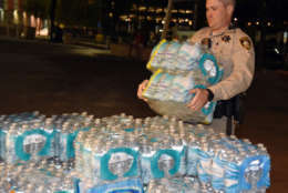 LAS VEGAS, NV - OCTOBER 02:  A Las Vegas Metropolitan Police Department officer helps deliver bottled water to people at the Thomas &amp; Mack Center after a mass shooting at a country music festival on October 2, 2017 in Las Vegas, Nevada. People who could not go to hotel-casinos that were closed after the shooting are temporarily staying at the center and residents are donating supplies. The gunman, identified as Stephen Paddock, 64, of Mesquite, Nevada, opened fire from the Mandalay Bay Resort and Casino on the music festival, leaving at least 50 people dead and hundreds injured. Police have confirmed that one suspect has been shot. The investigation is ongoing.   (Photo by Ethan Miller/Getty Images)