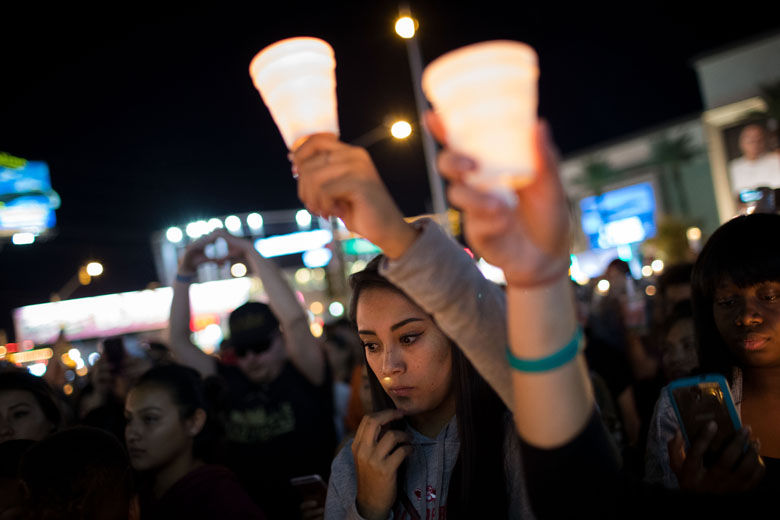 LAS VEGAS, NV - OCTOBER 2: Mourners attend a candlelight vigil at the corner of Sahara Avenue and Las Vegas Boulevard  for the victims of Sunday night's mass shooting, October 2, 2017 in Las Vegas, Nevada. Late Sunday night, a lone gunman killed more than 50 people and injured more than 500 people after he opened fire on a large crowd at the Route 91 Harvest Festival, a three-day country music festival. The massacre is one of the deadliest mass shooting events in U.S. history. (Photo by Drew Angerer/Getty Images)
