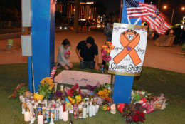 LAS VEGAS, NV - OCTOBER 03:  People sign a poster at a makeshift memorial at the base of the Welcome to Fabulous Las Vegas sign in memory of the victims of Sunday night's shooting, on October 3, 2017 in Las Vegas, Nevada. Late Sunday night, a lone gunman killed at least 59 people and injured more than 500 after he opened fire on a large crowd at the Route 91 Harvest country music festival. The massacre is one of the deadliest mass shooting events in U.S. history.  (Photo by Ethan Miller/Getty Images)