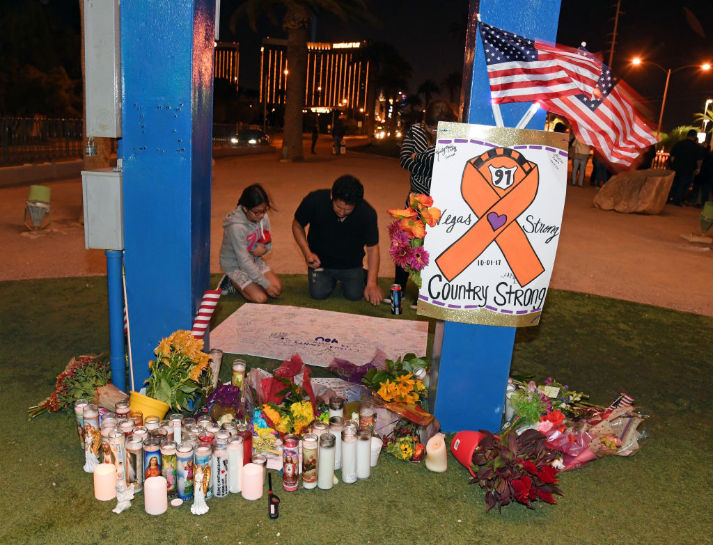 LAS VEGAS, NV - OCTOBER 03:  People sign a poster at a makeshift memorial at the base of the Welcome to Fabulous Las Vegas sign in memory of the victims of Sunday night's shooting, on October 3, 2017 in Las Vegas, Nevada. Late Sunday night, a lone gunman killed at least 59 people and injured more than 500 after he opened fire on a large crowd at the Route 91 Harvest country music festival. The massacre is one of the deadliest mass shooting events in U.S. history.  (Photo by Ethan Miller/Getty Images)