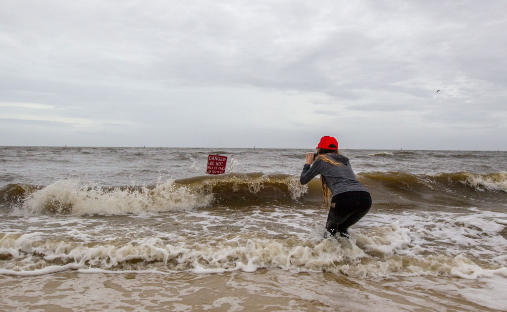 GULFPORT,MS-OCTOBER 7, 2017: Hannah Jacole Powell-Yost takes photos of a danger sign in the Gulf surf in Gulfport, Mississippi as Hurricane Nate approaches the northern Mississippi Gulf Coast on October 7, 2017 in Gulfport, Mississippi. October 7, 2017. Nate is expected to make landfall in the overnight hours as a category 2 storm. (Photo by Mark Wallheiser/Getty Images)