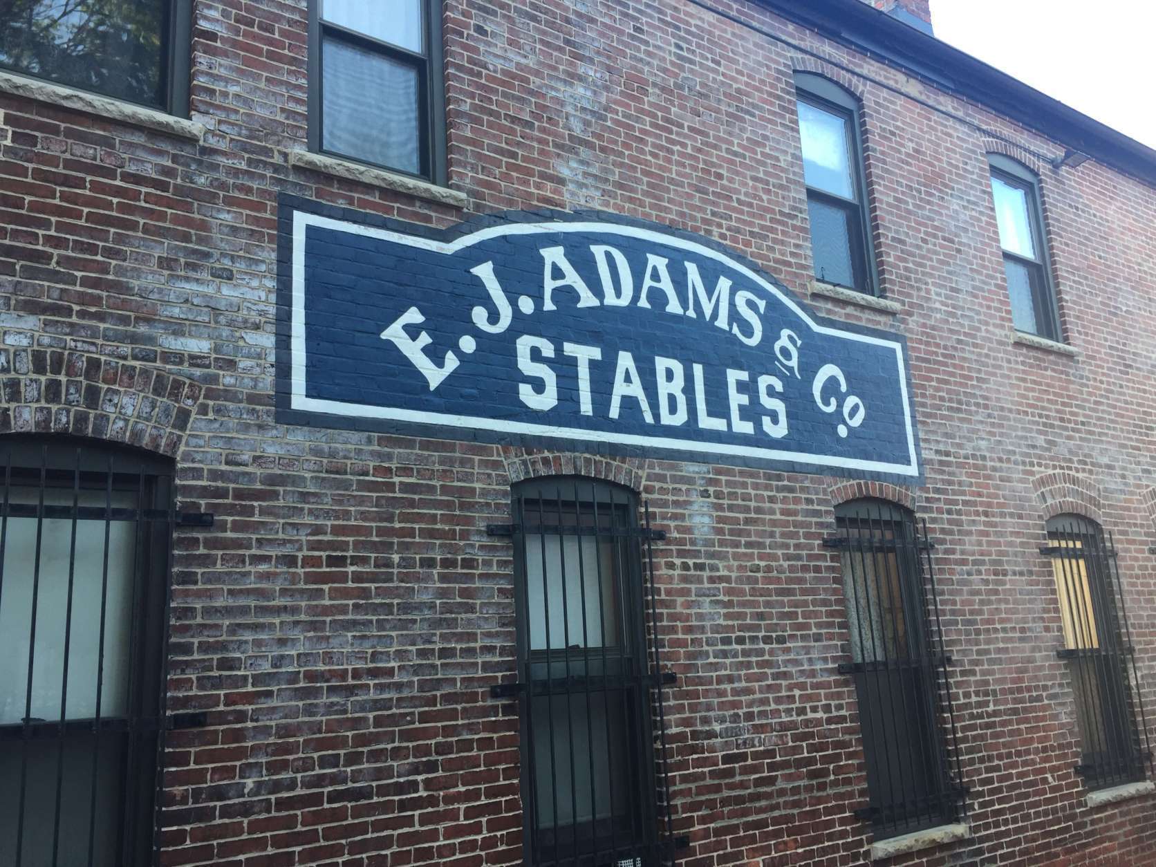 Down the alley, at 1315 Naylor Court NW, another restored sign overlooks an alley. (WTOP/Jack Pointer)
