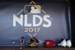 Washington Nationals player equipment sits in the dugout under an NLDS logo during a baseball workout at Nationals Park, Wednesday, Oct. 4, 2017, in Washington. The Nationals host the Chicago Cubs in Game 1 of the National League Division Series on Friday. (AP Photo/Mark Tenally)