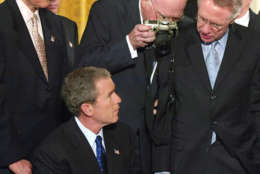 Sen Patrick Leahy D-Vt. peers over the shoulder with his camera as President Bush signs the Patriot Act Bill during a ceremony in the White House East Room, Friday, Oct. 26, 2001. The law gives police unprecedented authority to search people's homes and business records secretly and eavesdrop on telephone and computer conversations and the government says it will begin using the new powers immediately. Left to right are: Sen. Orrin Hatch, R-Utah, Patrick Leahy, D-Vt.,  Sen. Harry Reid, D-Nev.      (AP Photo/Doug Mills)