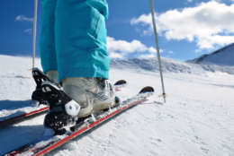 woman's legs in ski boots, standing on skis