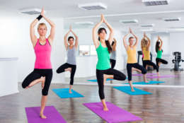Four girls practicing yoga, Yoga-Tree pose/Vrikshasana