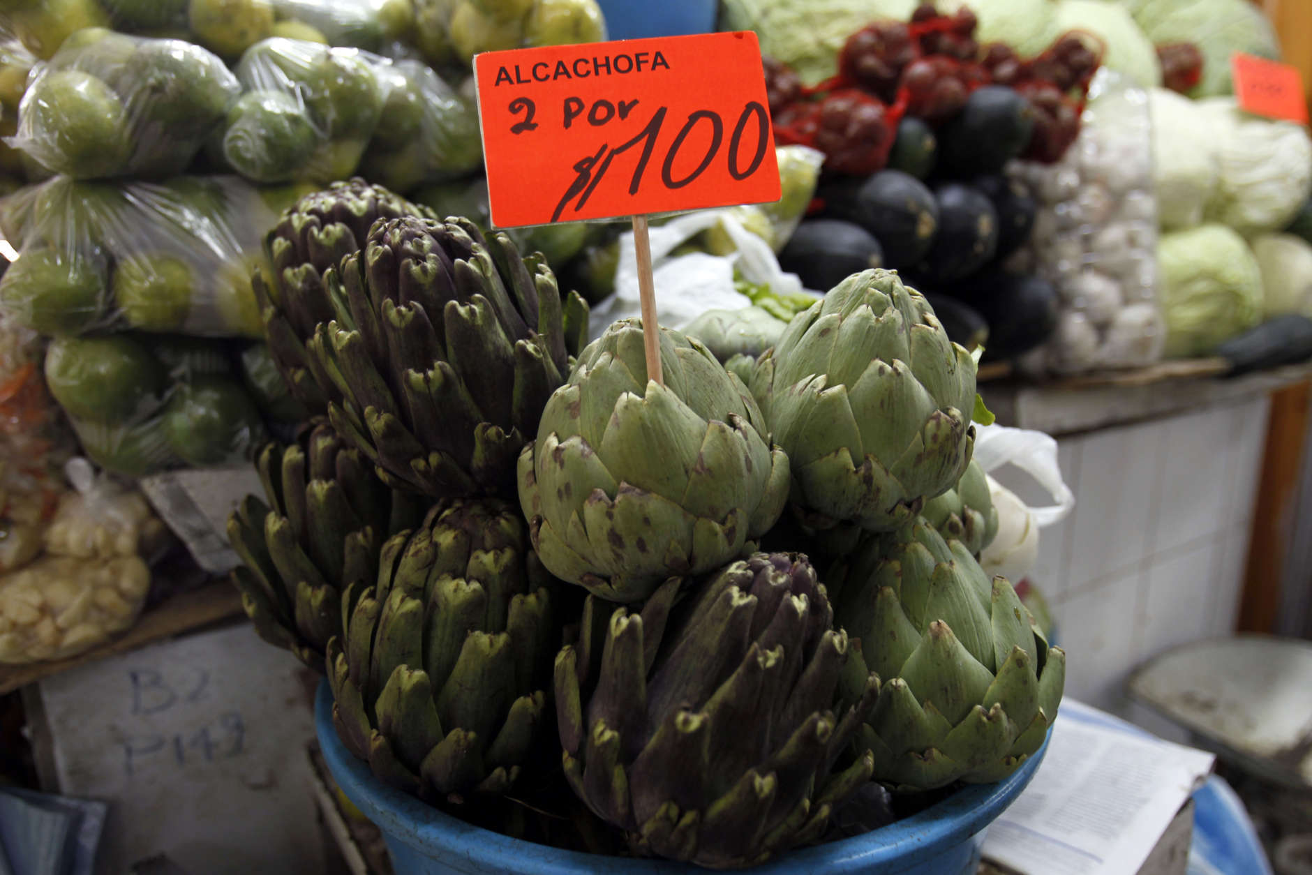 Artichokes sit for sale, with a sign that reads "Two for $1 dollar" at a market in downtown Quito, Ecuador, Thursday, June 27, 2013. Unlike with China, Russia or Cuba, countries where the U.S. has relatively few tools to force Edward Snowden's handover, the Obama administration could swiftly hit Ecuador in the pocketbook by denying reduced tariffs on cut flowers, artichokes and broccoli if it grants Snowden's request for asylum. Those represent hundreds of millions of dollars in annual exports for this country where nearly half of foreign trade depends on the U.S. (AP Photo/Dolores Ochoa)