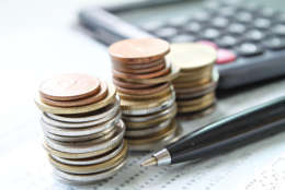 Business, finance, saving money, banking, loan, investment, taxes or accounting concept : Coins stack, pen and calculator on office desk table