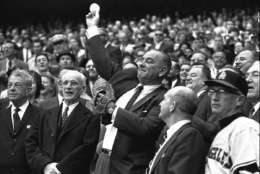 President Lyndon Johnson throws out the first ball to open the American League baseball season, April 13, 1964.  The first pitch ceremony preceded the opening game between the Los Angeles Angels and the Washington Senators.  At left is House Speaker John McCormack of Massachusetts.  (AP Photo)