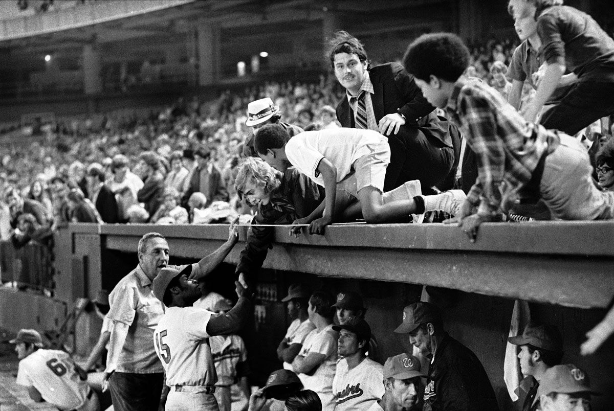 Dave Nelson of the Washington Senators shakes hands with fans before fans stopped the game by storming the field in the ninth inning in Washington, Oct. 1, 1971. The Senators forfeited the game to the New York Yankees due to fans' actions. (AP Photo/Jim Palmer)