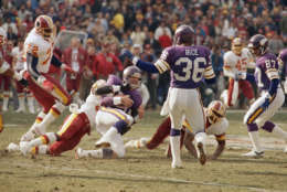 Minnesota Vikings Quarterback Wade Wilson, third from left, is brought down after running from the pocket by Washington Redskins Safety Clarence Vaughn, second from left, during first quarter championship game action at RFK Stadium, Sunday, Jan. 17, 1988, Washington, D.C. (AP Photo/Scott Stewart)